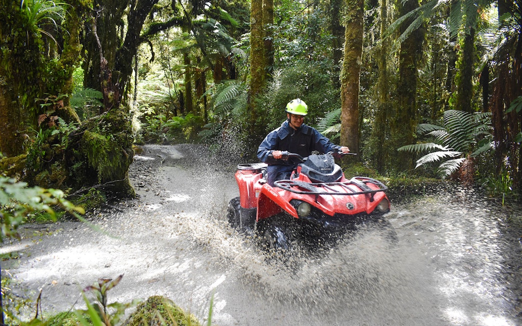 Quad biking through forest trail at Franz Josef, New Zealand.