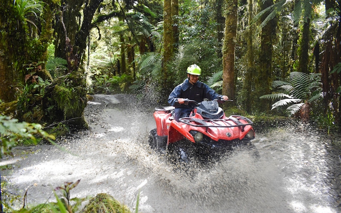 Quad biking through forest trail at Franz Josef, New Zealand.