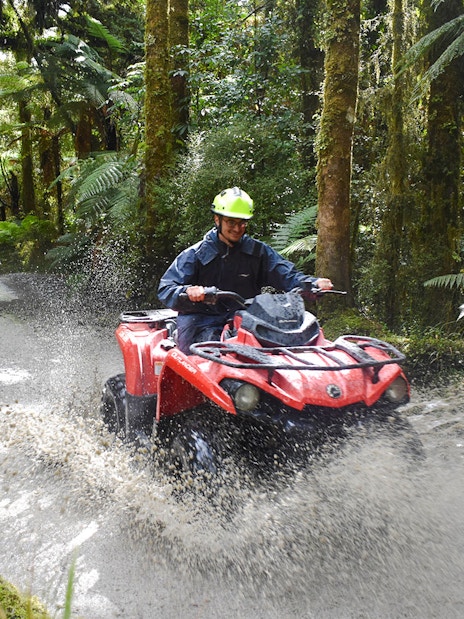 Quad biking through forest trail at Franz Josef, New Zealand.