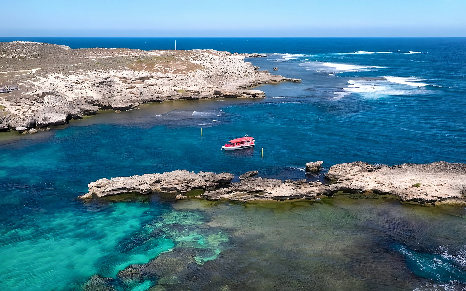 Group of tourists enjoying the Rottnest Island Ferry and Adventure Boat Tour, with a view of the Perth skyline in the background