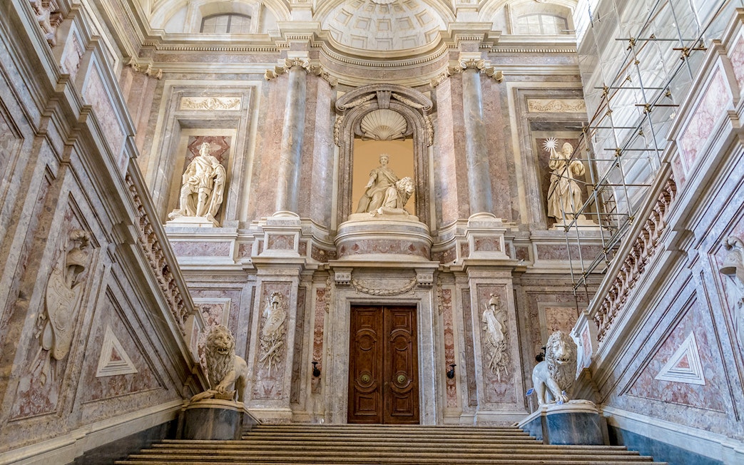 Staircase of Honour with statues and ornate architecture in the Royal Palace of Caserta.