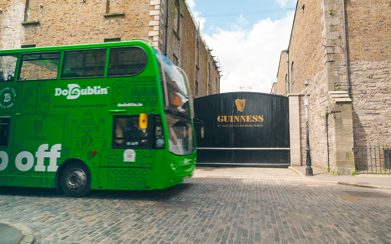 Dublin hop-on hop-off bus passing Guinness Storehouse entrance.