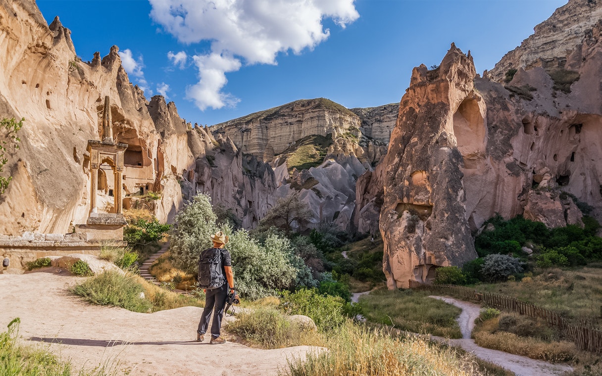 Traveler exploring rock formations at Zelve Open Air Museum, Cappadocia.