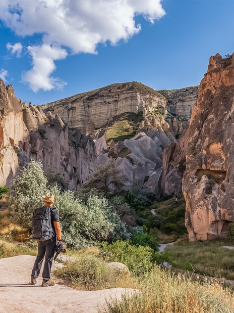 Traveler exploring rock formations at Zelve Open Air Museum, Cappadocia.