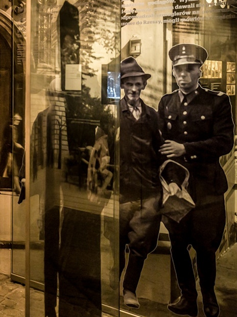 Exhibit at Schindler's Factory Museum in Krakow, showcasing historical photos and artifacts.