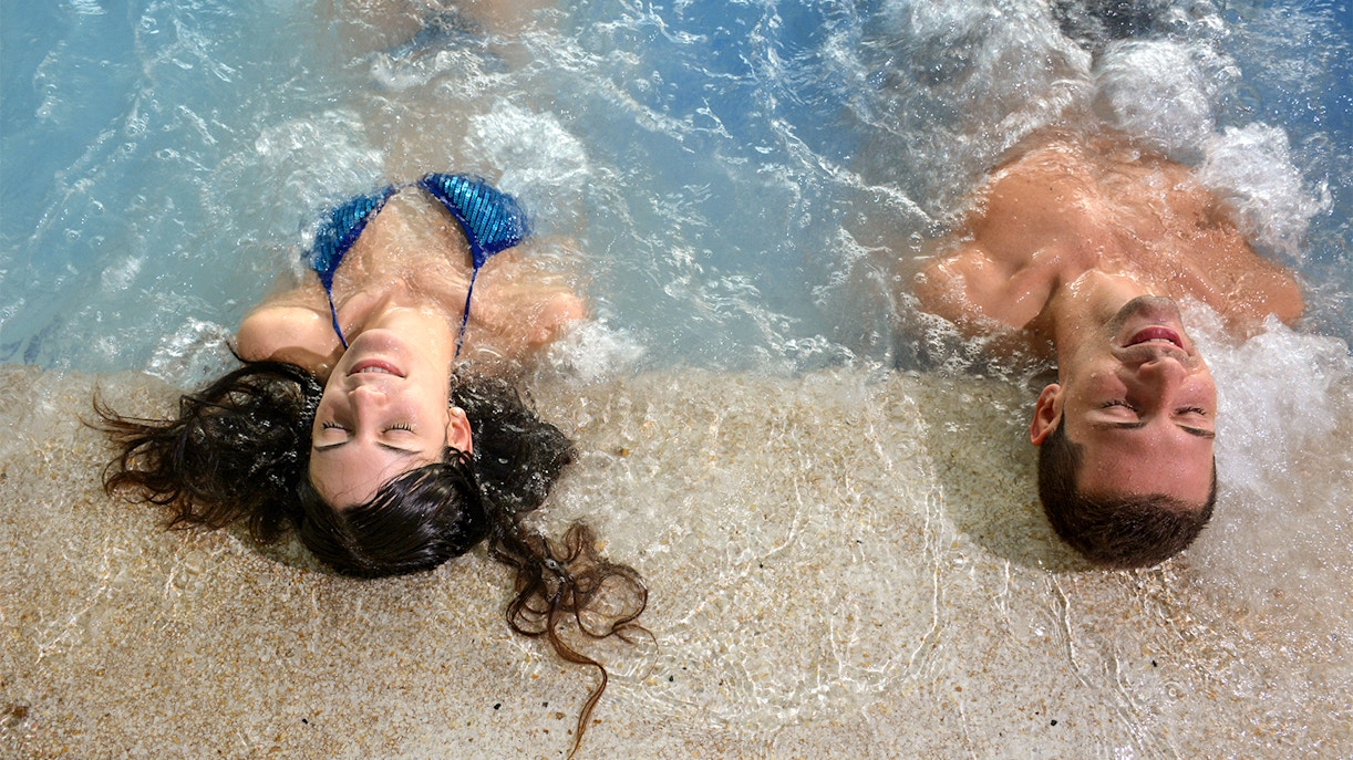 People relaxing in a thermal bath, enjoying the water.