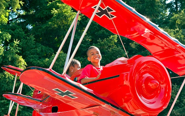 Children enjoying the SNOOPY® vs Red Baron ride at Canada's Wonderland.