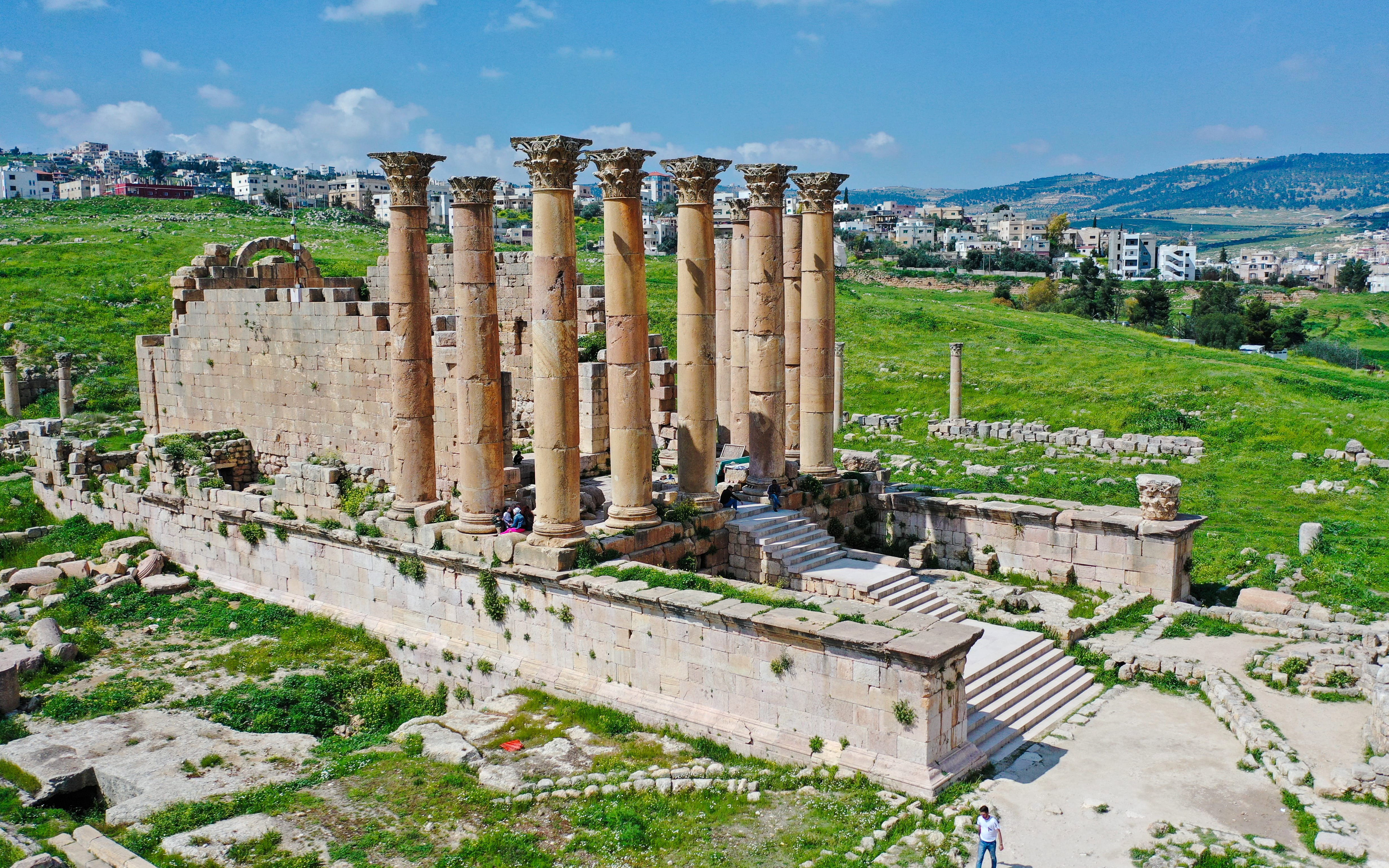 Temple of Artemis ruins in Jerash, Jordan, with ancient columns and surrounding landscape.