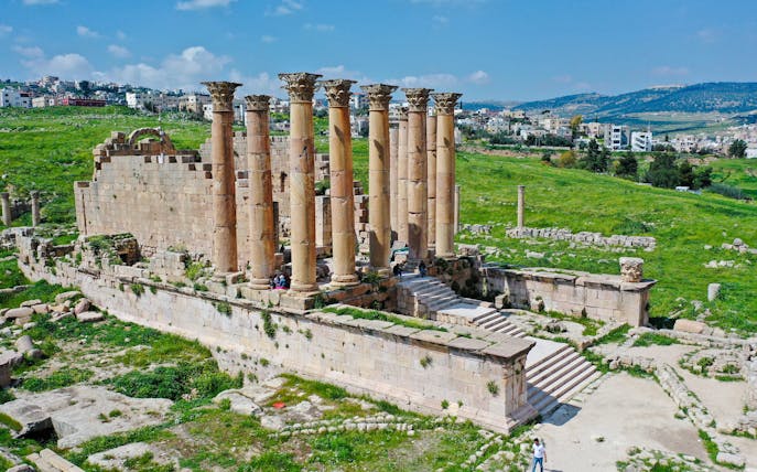 Temple of Artemis ruins in Jerash, Jordan, with ancient columns and surrounding landscape.