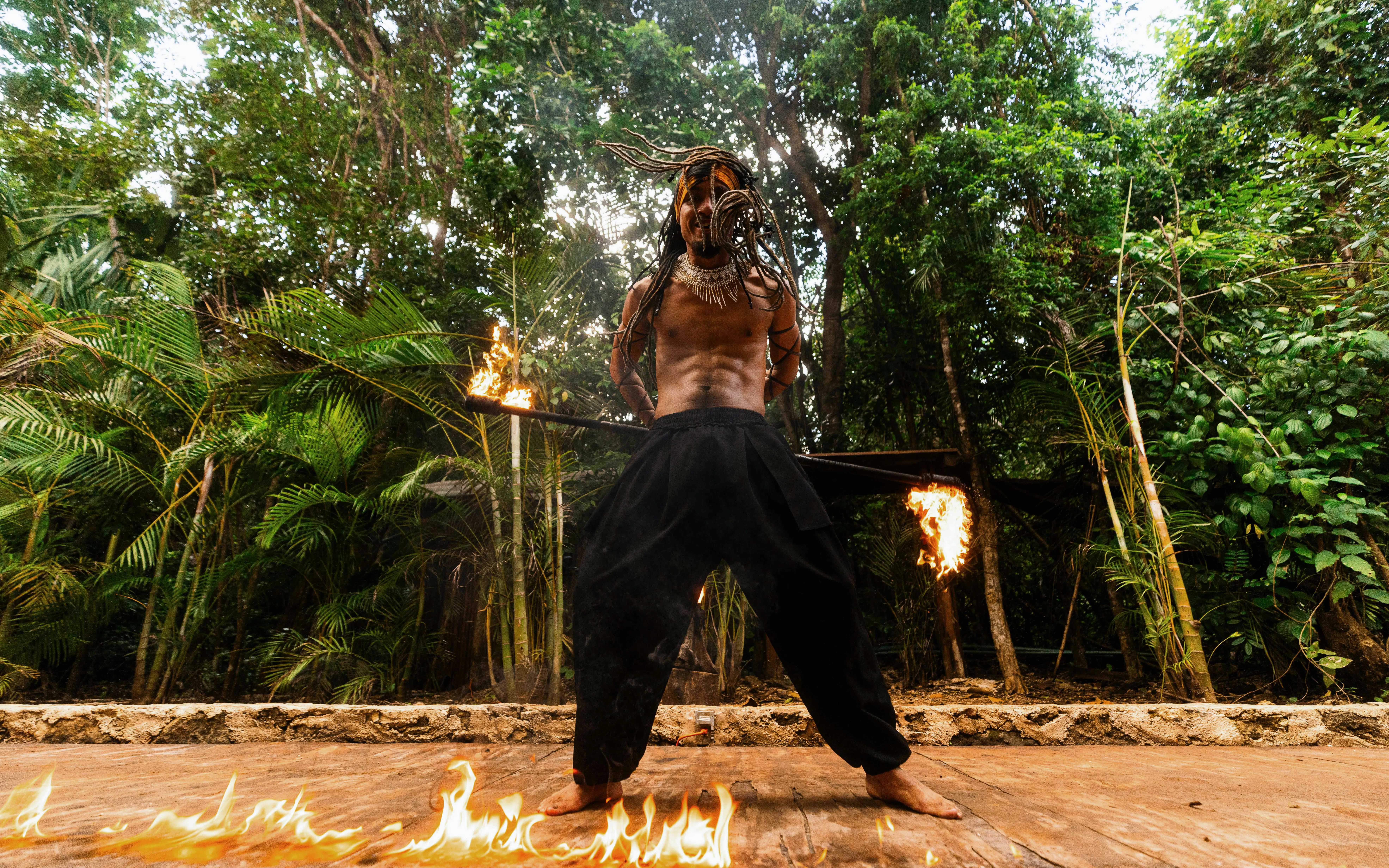 Performer with flaming staff at Cancun Extreme Adventuring Park.