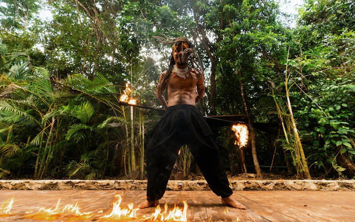 Performer with flaming staff at Cancun Extreme Adventuring Park.