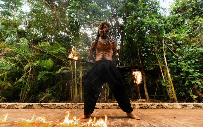 Performer with flaming staff at Cancun Extreme Adventuring Park.