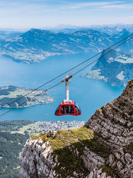 Cable car ascending Mount Pilatus with Lake Lucerne in the background.