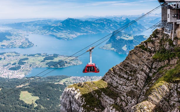 Cable car ascending Mount Pilatus with Lake Lucerne in the background.