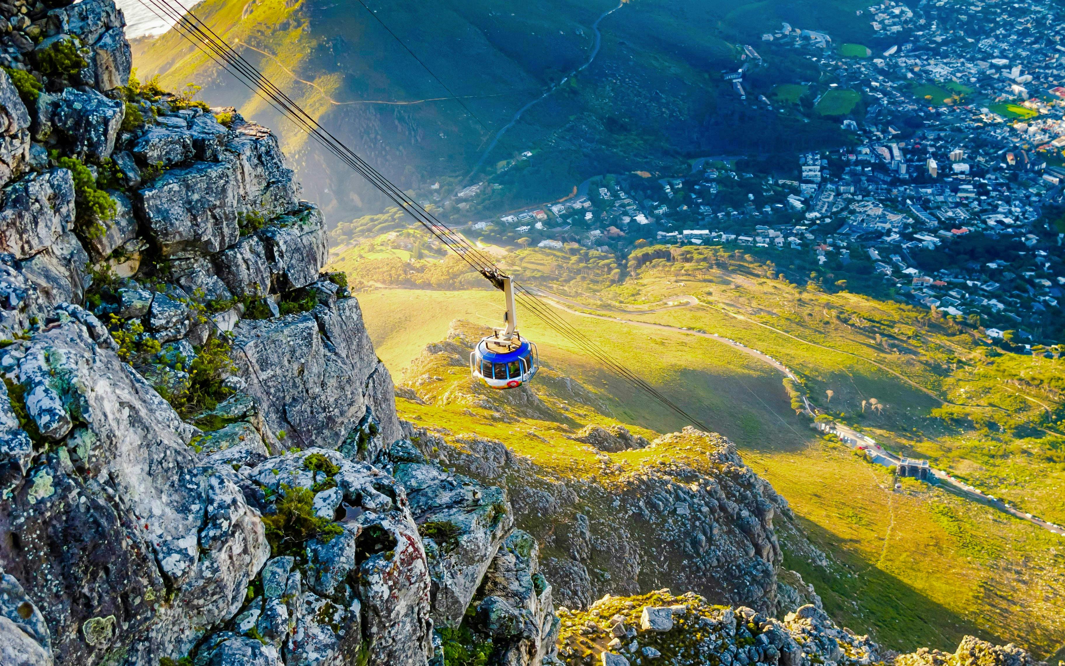 Cable car ascending Table Mountain with Cape Town view below, South Africa.