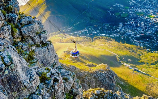 Cable car ascending Table Mountain with Cape Town view below, South Africa.