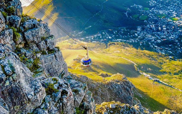 Cable car ascending Table Mountain with Cape Town view below, South Africa.