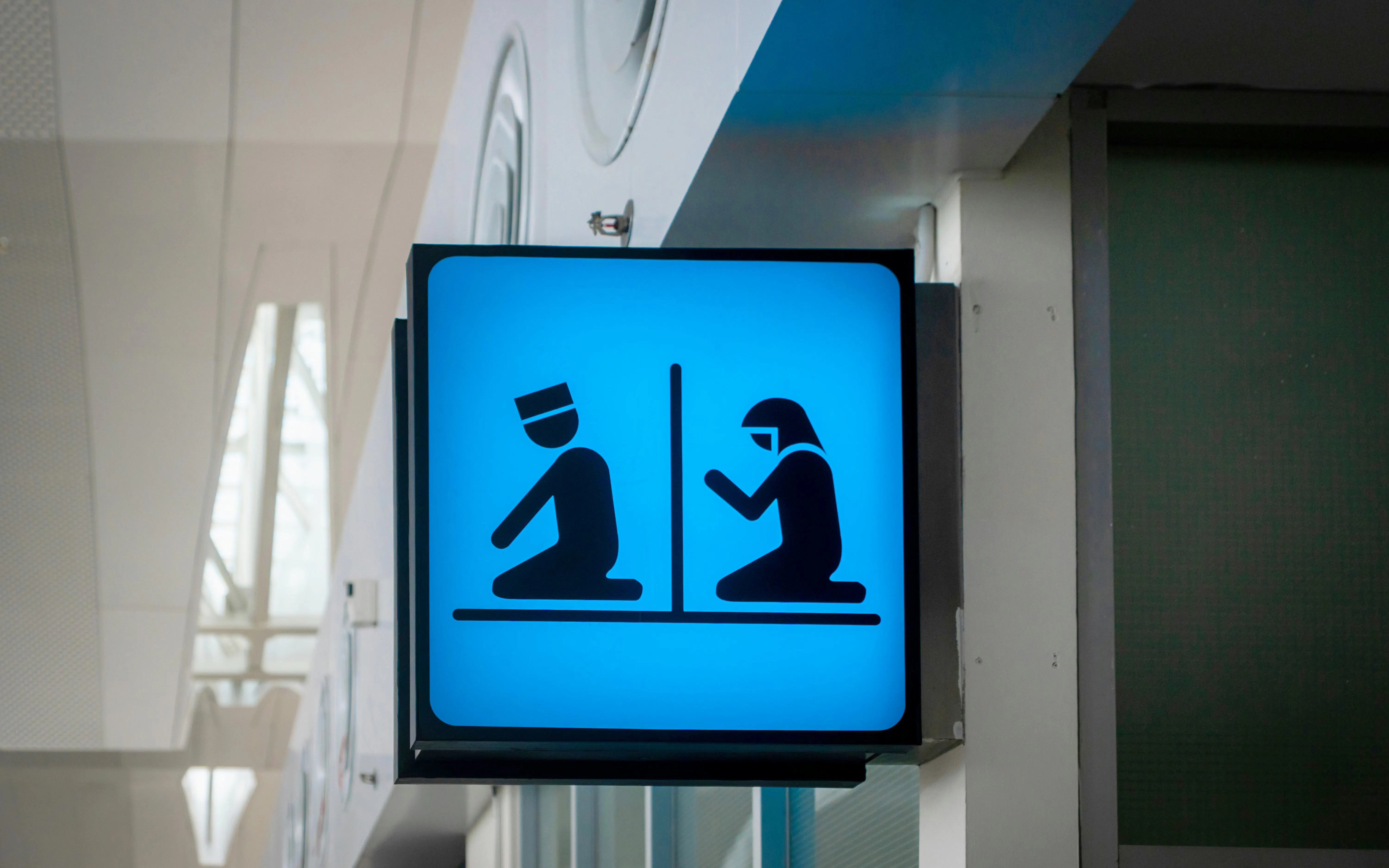 Prayer room sign with male and female symbols in an airport.