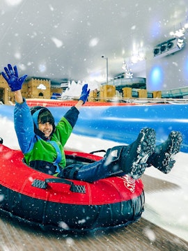 Person enjoying snow tubing at Snow Dunes Theme Park.