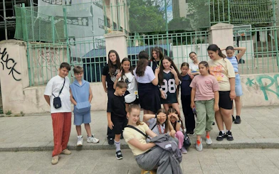 Group of children posing in front of a fenced area in Constanta for a self-guided city exploration game.