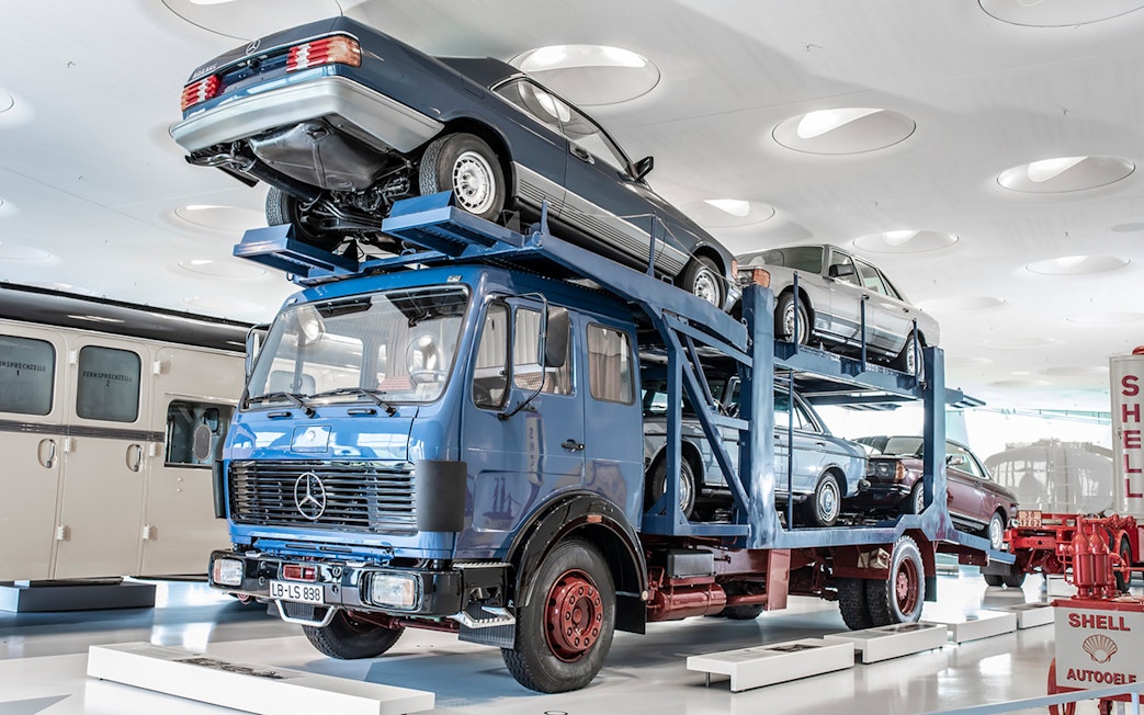 Car transporter exhibit at Mercedes Benz Museum, Stuttgart, showcasing vintage vehicles.