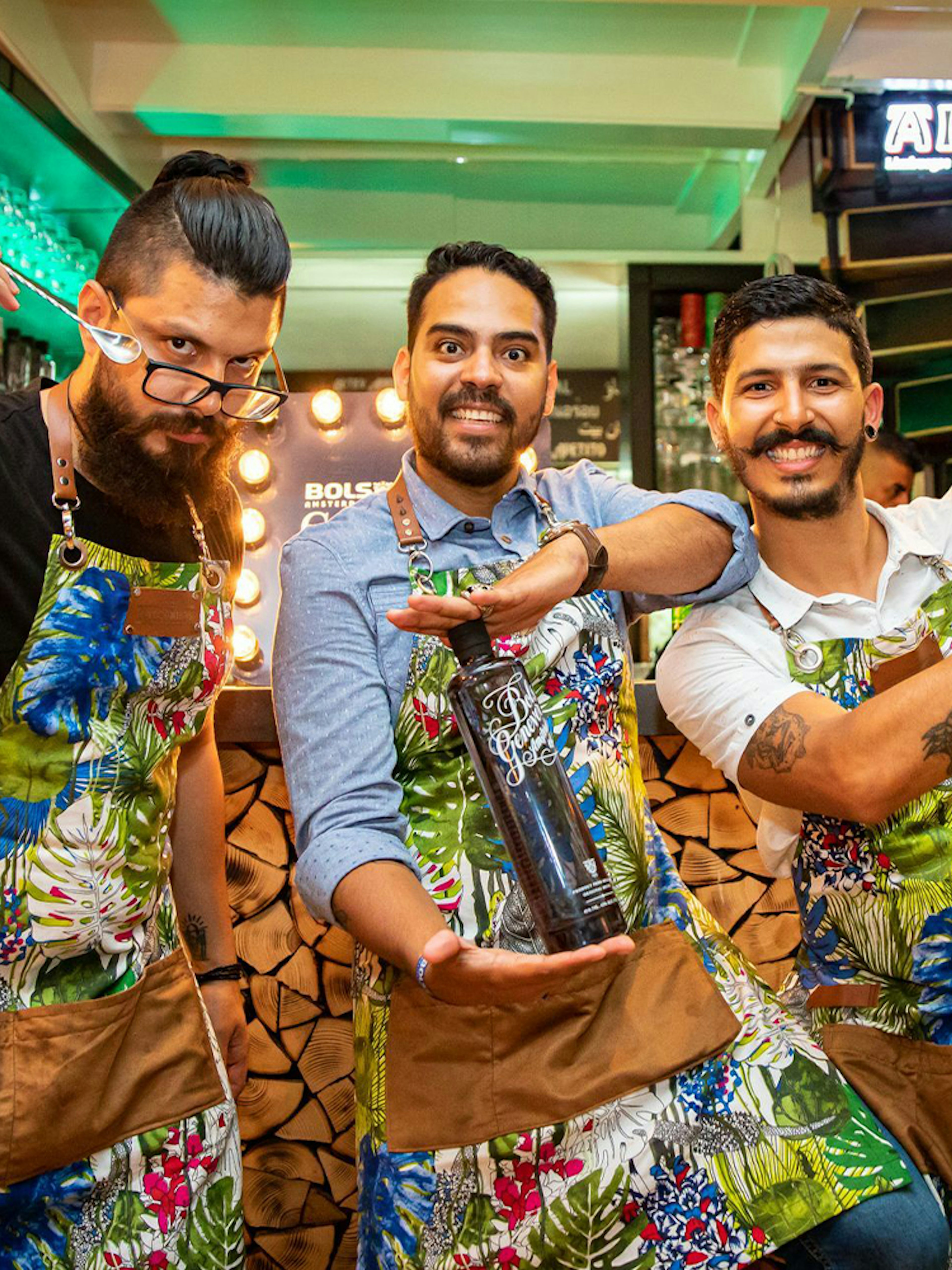 Bartenders at Amsterdam House of Bols cocktail workshop holding shakers and bottles.