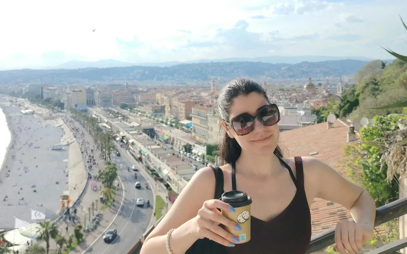 Nice cityscape view with a person holding a coffee, part of the Nice Murder Mystery self-guided game.