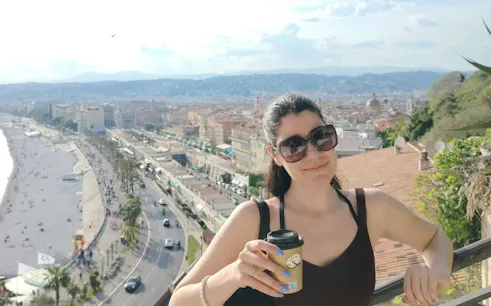Nice cityscape view with a person holding a coffee, part of the Nice Murder Mystery self-guided game.