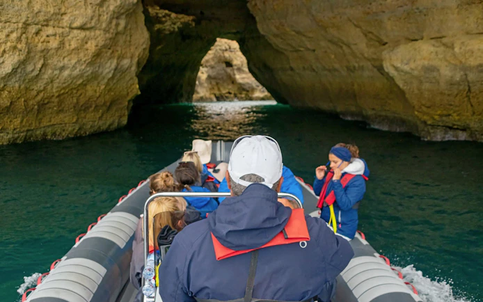Tourists on RIB boat entering Benagil Caves in Algarve, Portugal.