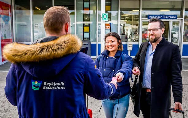 Reykjavik Excursions staff assisting travelers with tickets at Reykjavik BSI Bus Terminal.