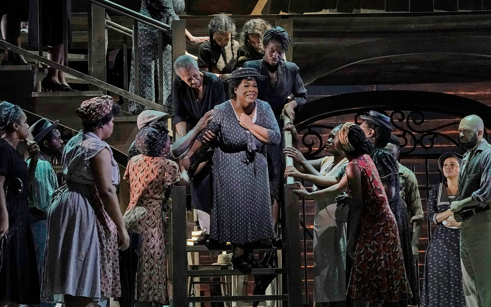 Actors performing on stage during Porgy and Bess show, surrounded by a lively ensemble.