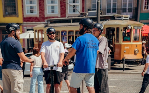Tourists on Segways with guide in front of tram during Porto tour.