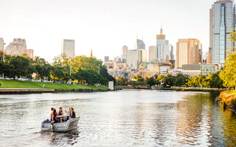 Group enjoying a self-drive picnic cruise on Yarra River with Melbourne skyline in background.