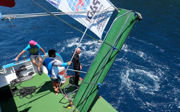 Divers preparing to enter the Mediterranean Sea from a boat.