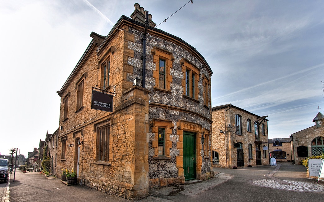 Cotswolds village street with historic stone buildings on a guided day tour from London.