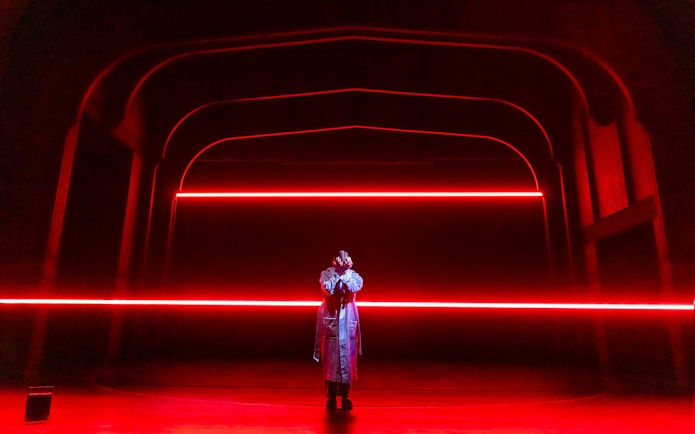 Performer on stage with red neon lights, Stranger Things theme.