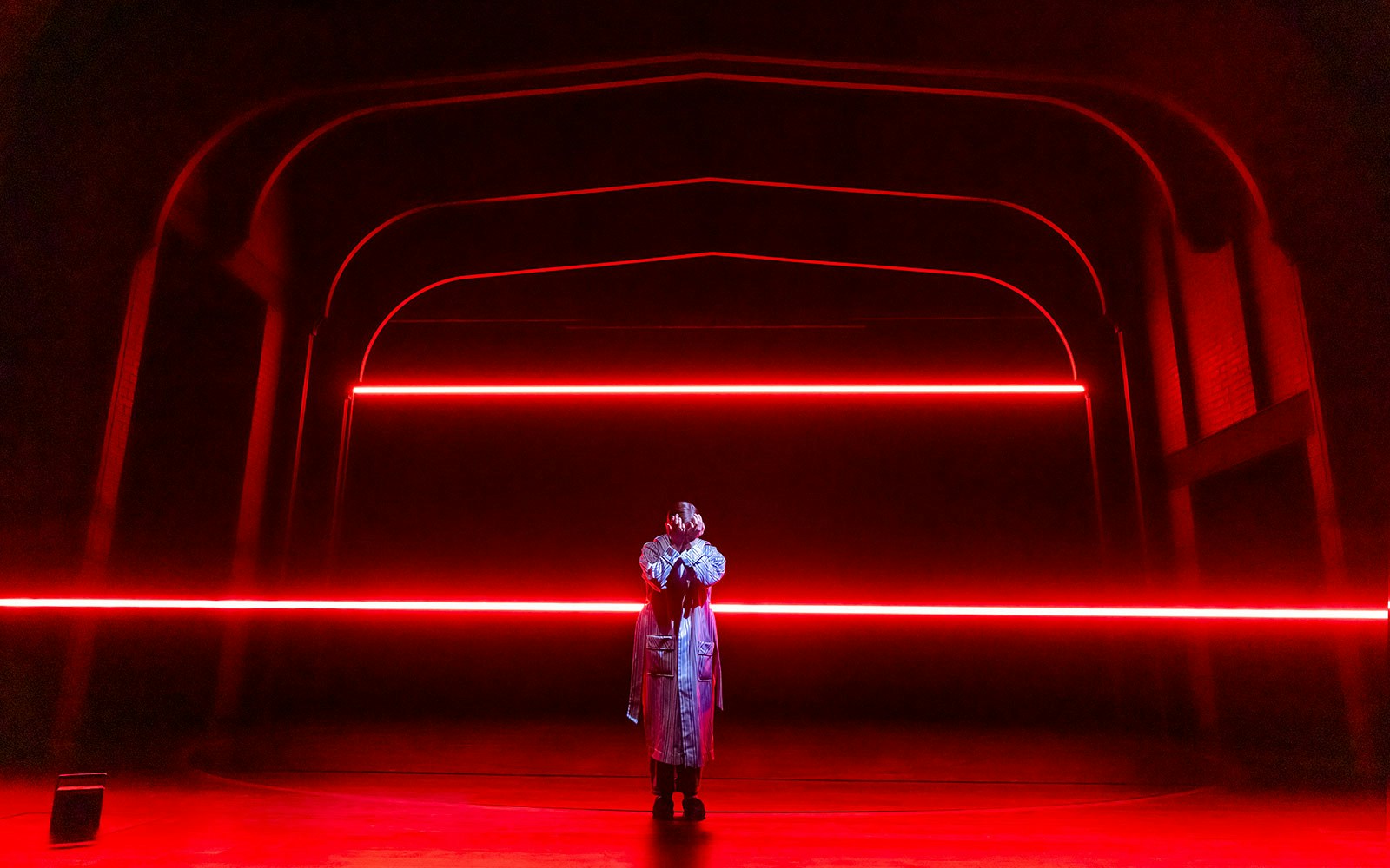 Performer on stage with red neon lights, Stranger Things theme.