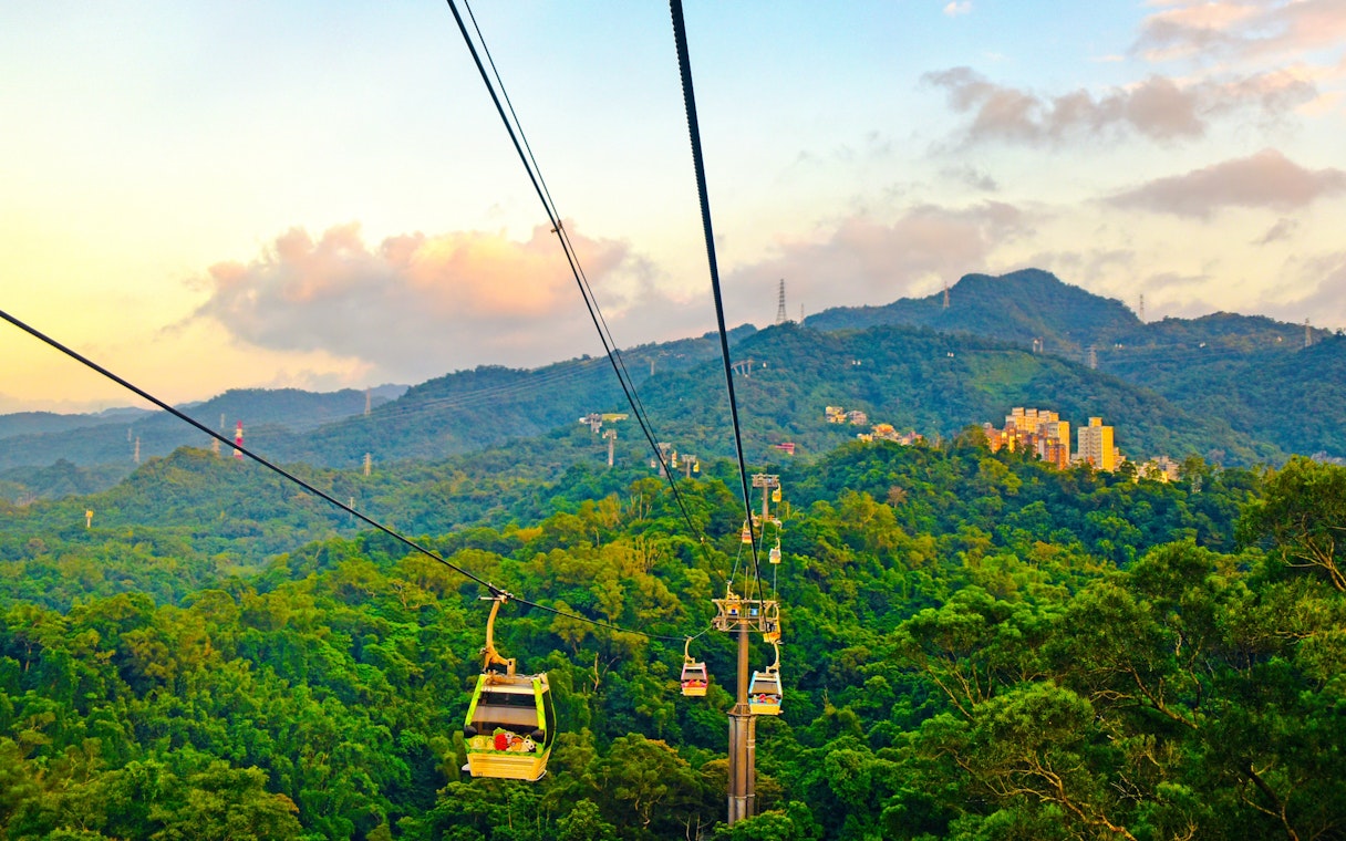 Maokong Gondola over lush hills in Taipei, Taiwan at sunset.