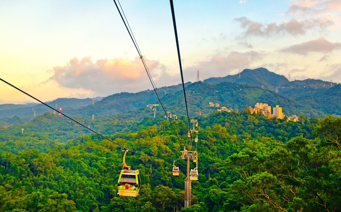 Maokong Gondola over lush hills in Taipei, Taiwan at sunset.