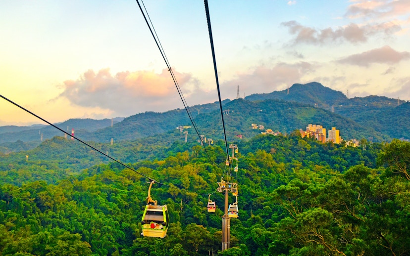 Maokong Gondola over lush hills in Taipei, Taiwan at sunset.