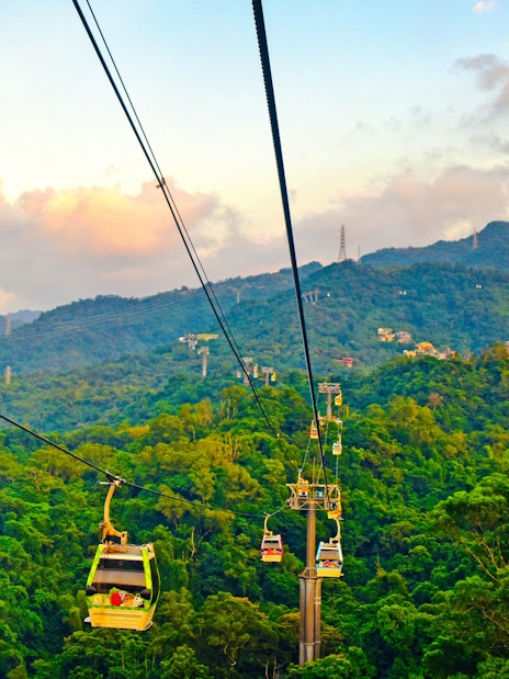 Maokong Gondola over lush hills in Taipei, Taiwan at sunset.