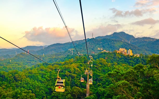Maokong Gondola over lush hills in Taipei, Taiwan at sunset.