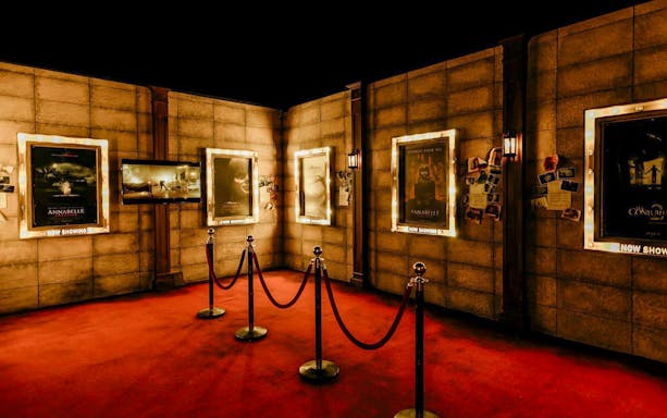 Movie posters from The Conjuring Universe displayed in a dimly lit exhibit in Thailand.