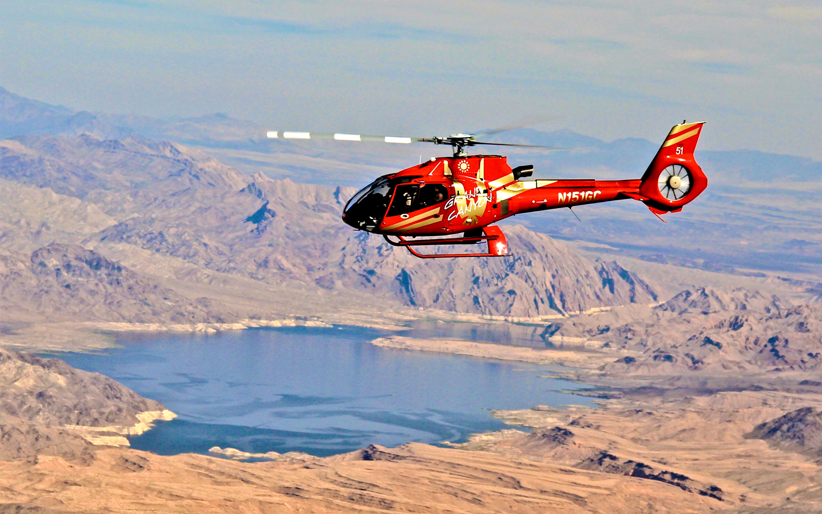 Red Papillon helicopter flying over Lake Mead near the Grand Canyon.
