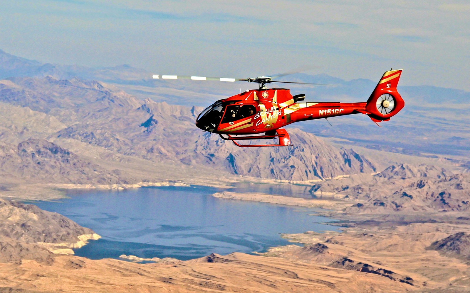 Red Papillon helicopter flying over Lake Mead near the Grand Canyon.