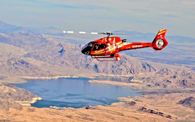 Red Papillon helicopter flying over Lake Mead near the Grand Canyon.