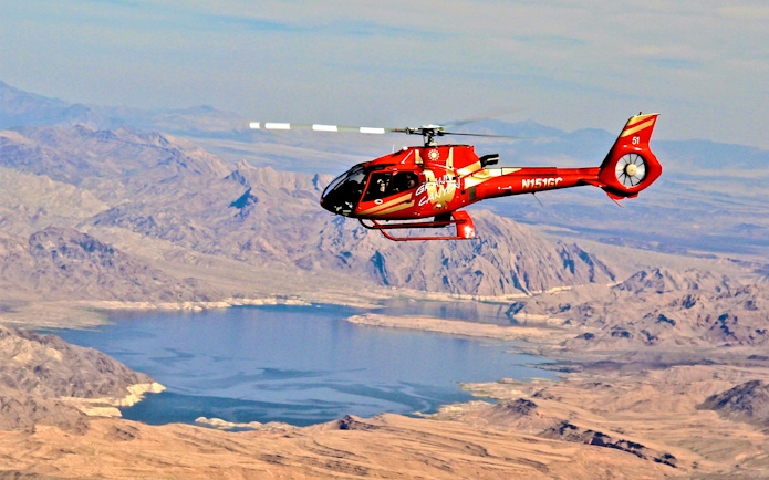 Red Papillon helicopter flying over Lake Mead near the Grand Canyon.