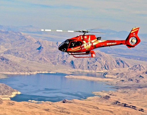 Red Papillon helicopter flying over Lake Mead near the Grand Canyon.