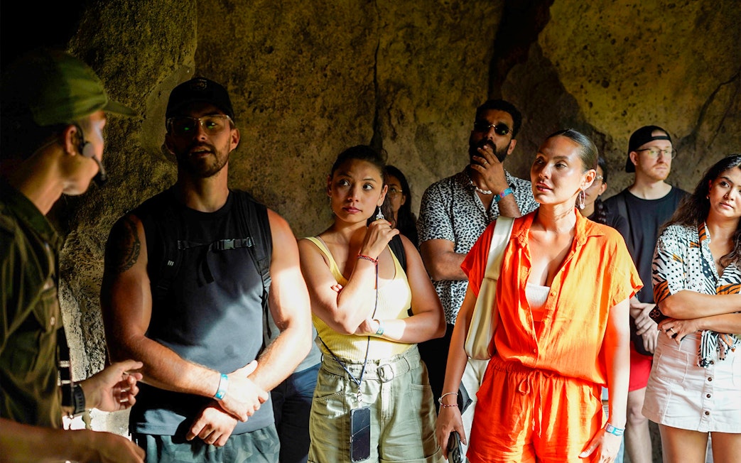 Tour group attentively listens to guide inside Bali Zoo.
