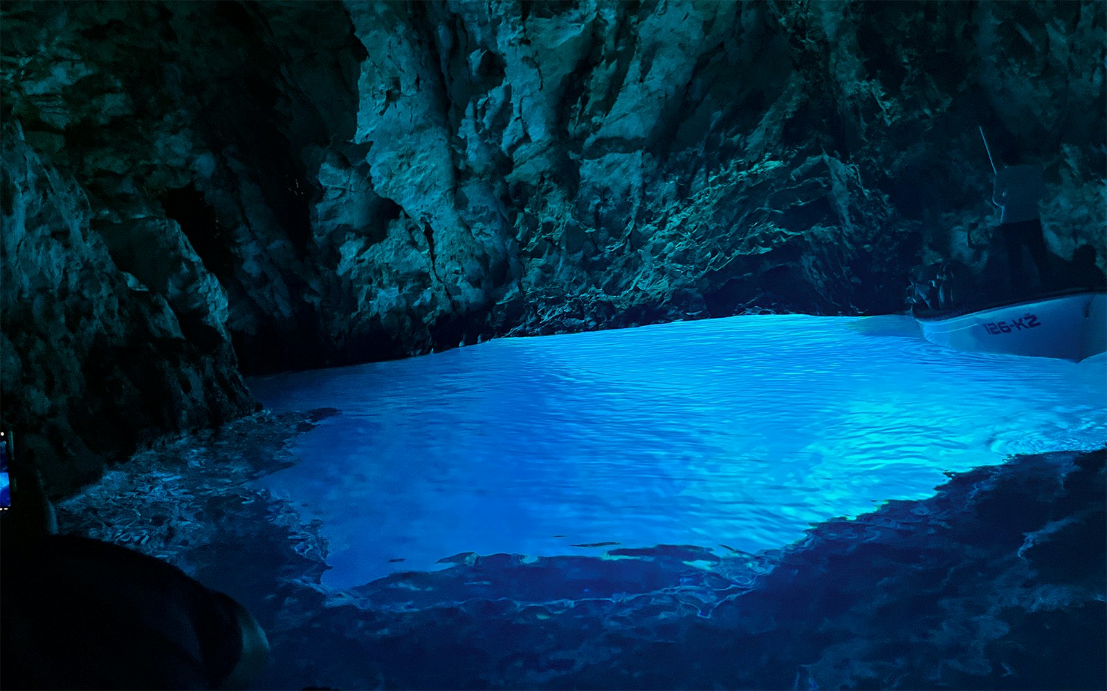 Blue Cave interior with glowing water and rocky walls, Croatia.